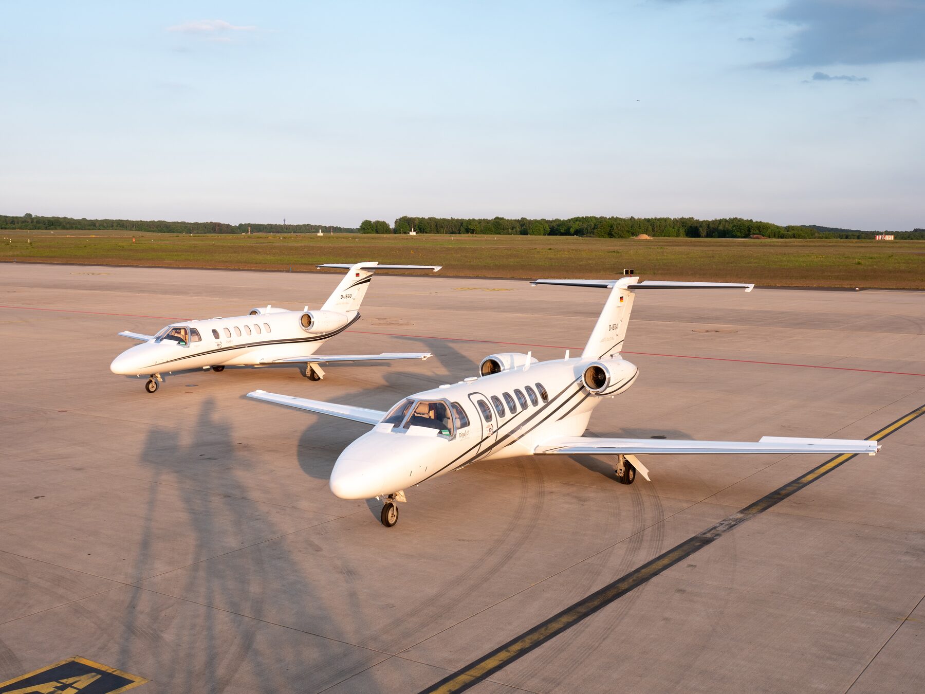 Two private jets on the tarmac at sunrise