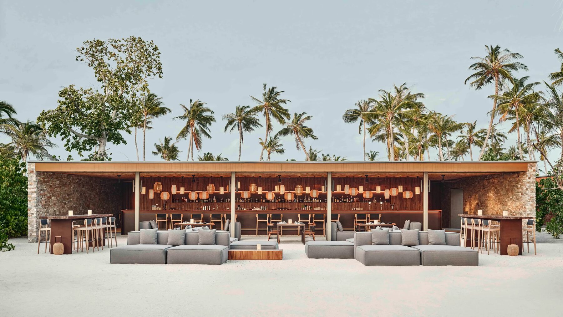 Open-air beach club bar among palm trees